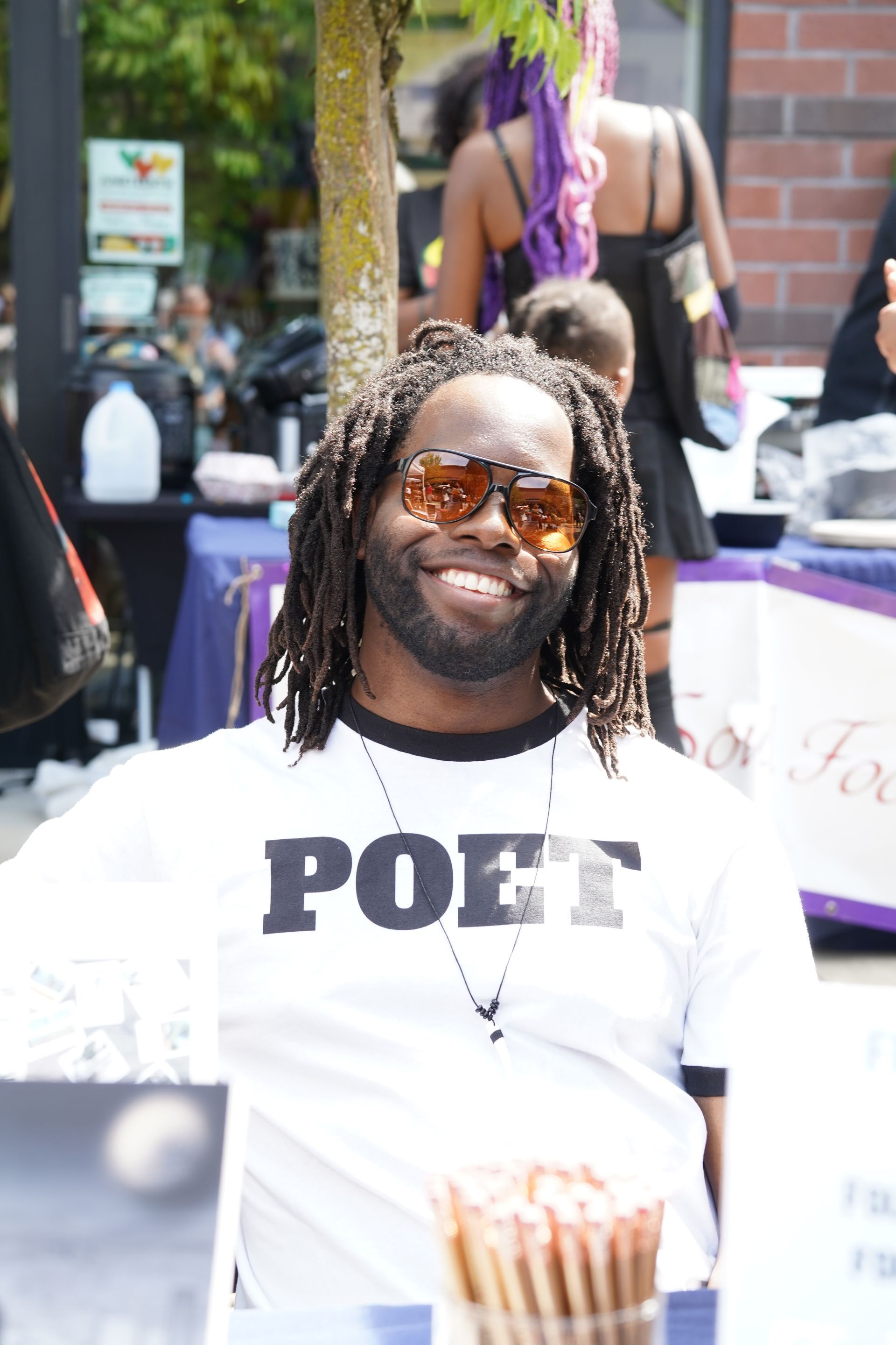 A man wearing a white shirt with the word poet on it