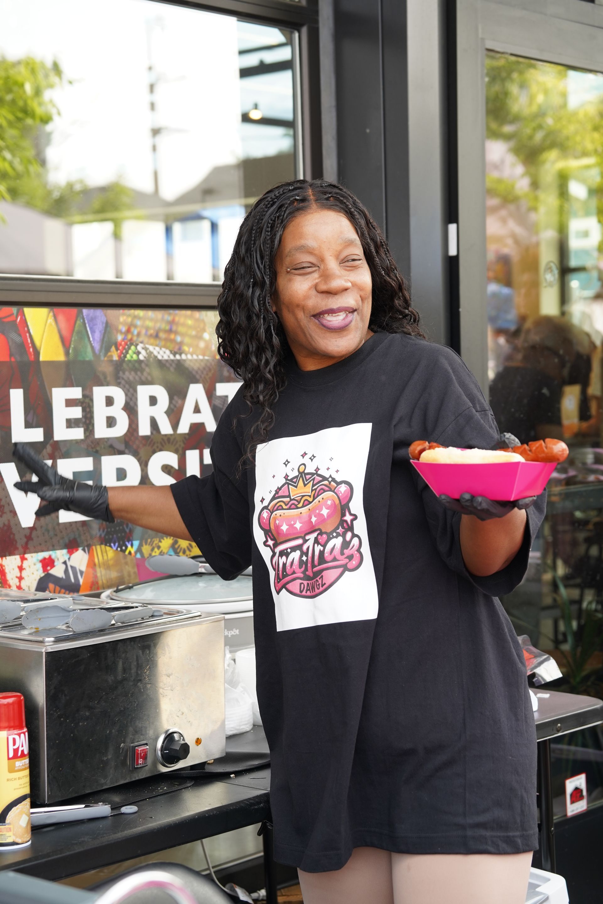 A woman in a black shirt is holding a plate of food.