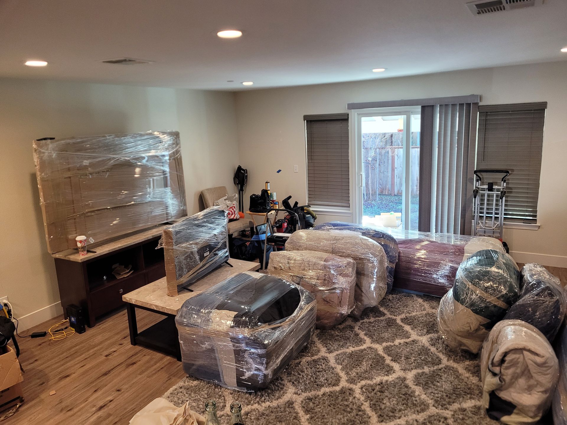 A living room filled with furniture wrapped in plastic.