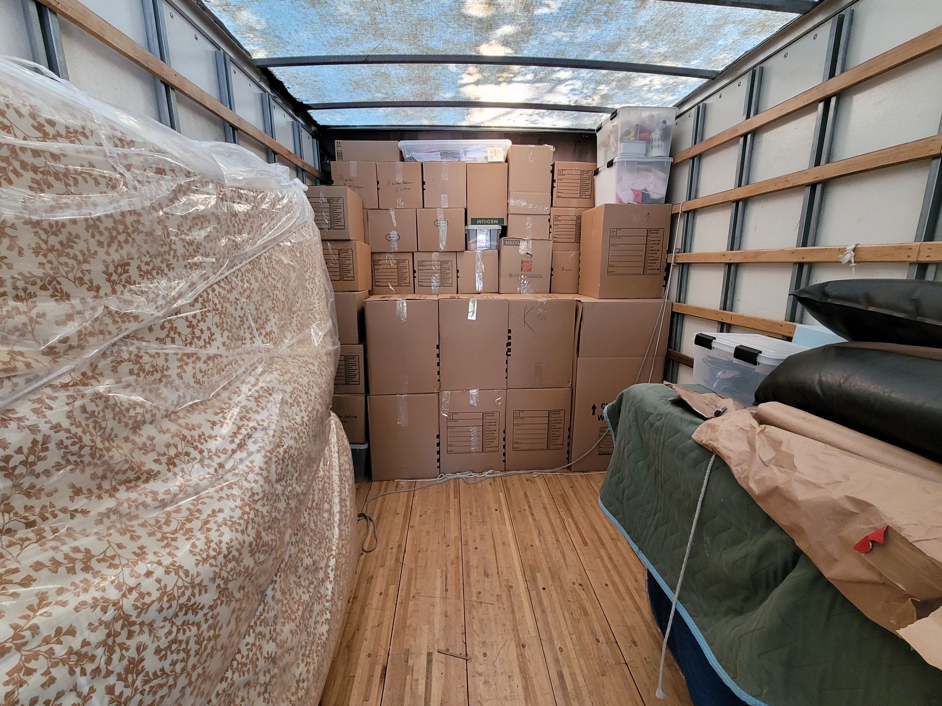 The inside of a moving truck filled with lots of boxes.