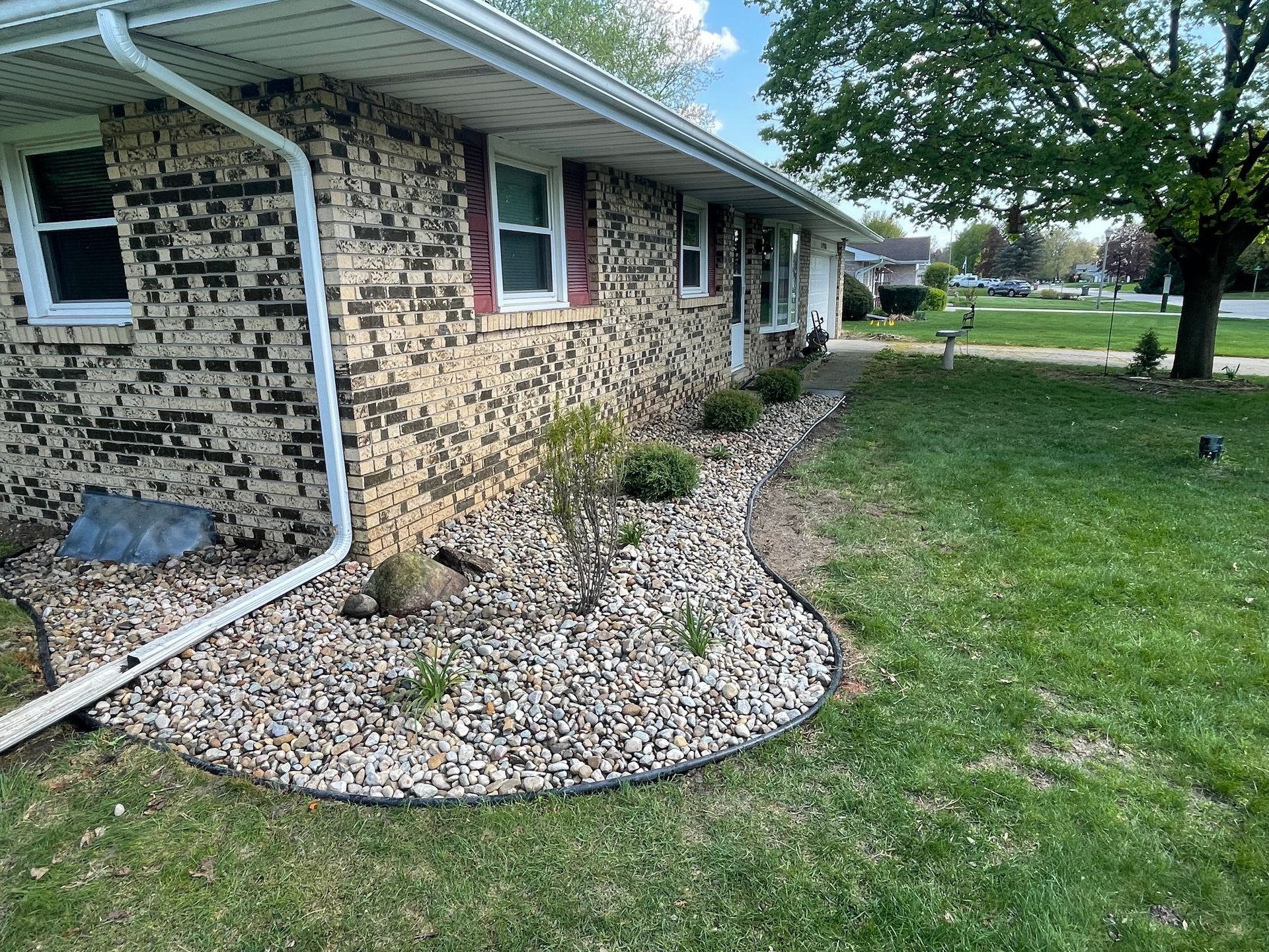 A brick house with a gravel garden in front of it.