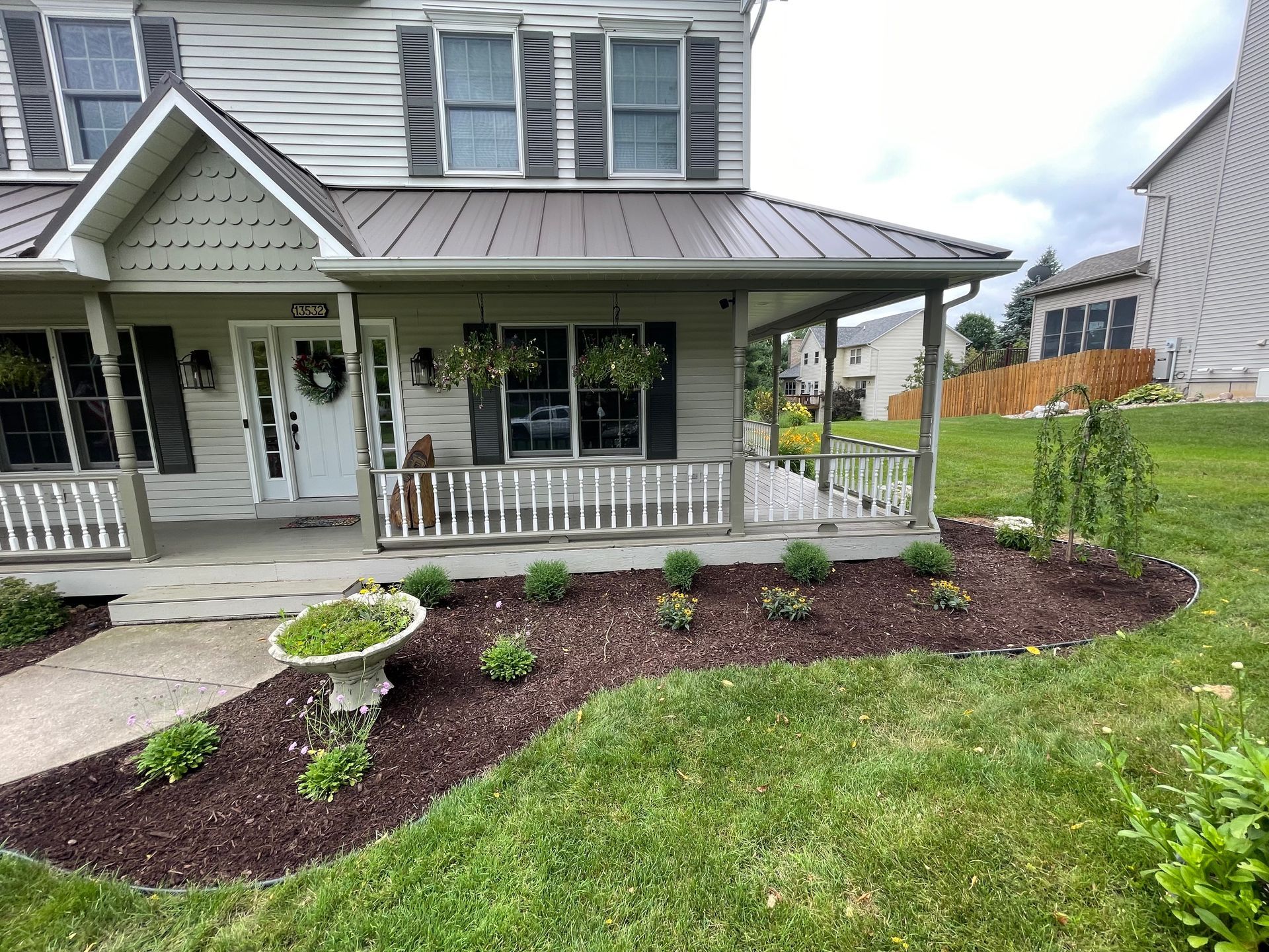 A white house with a metal roof and a porch.