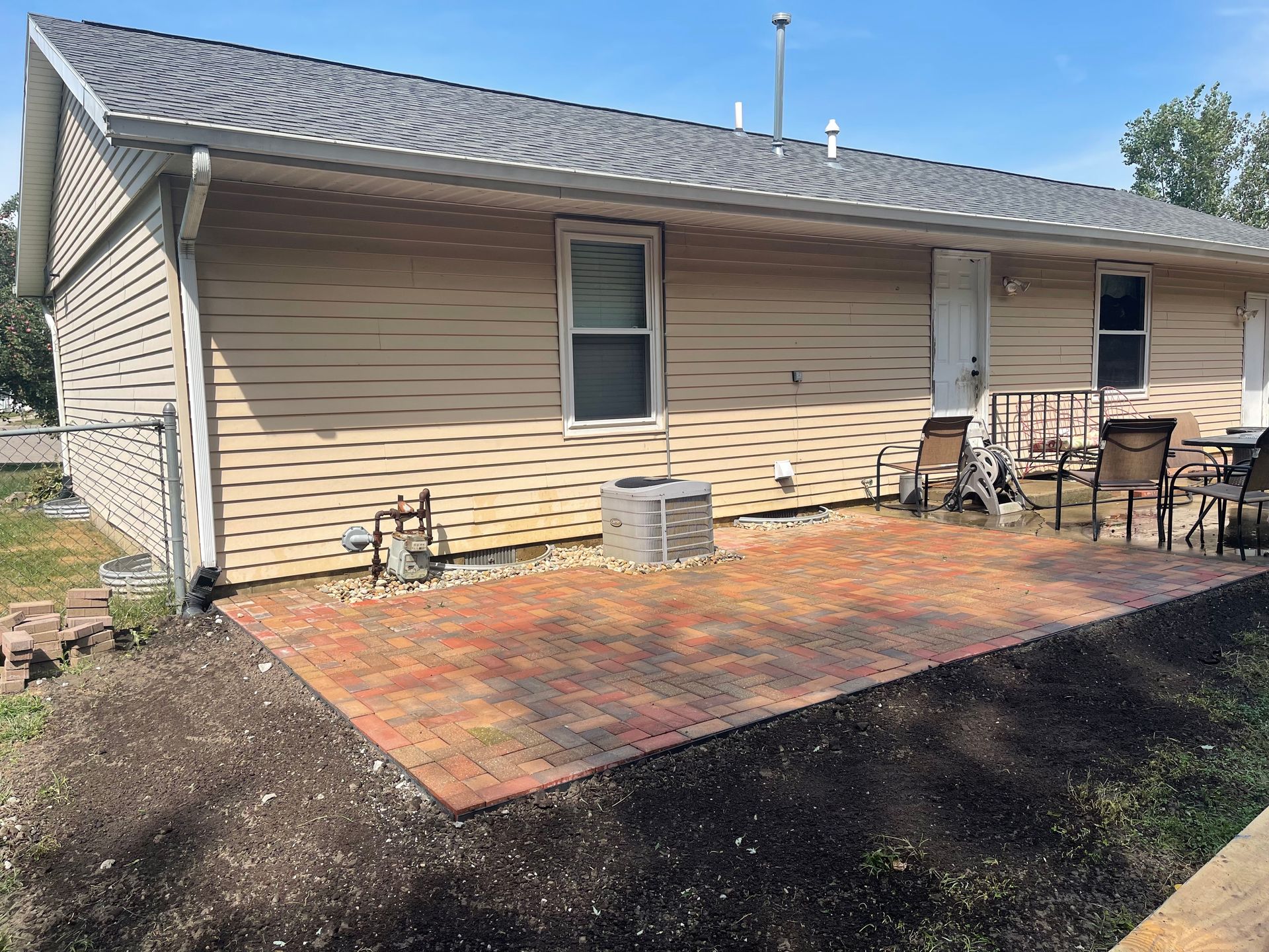 A house with a patio and chairs in front of it.
