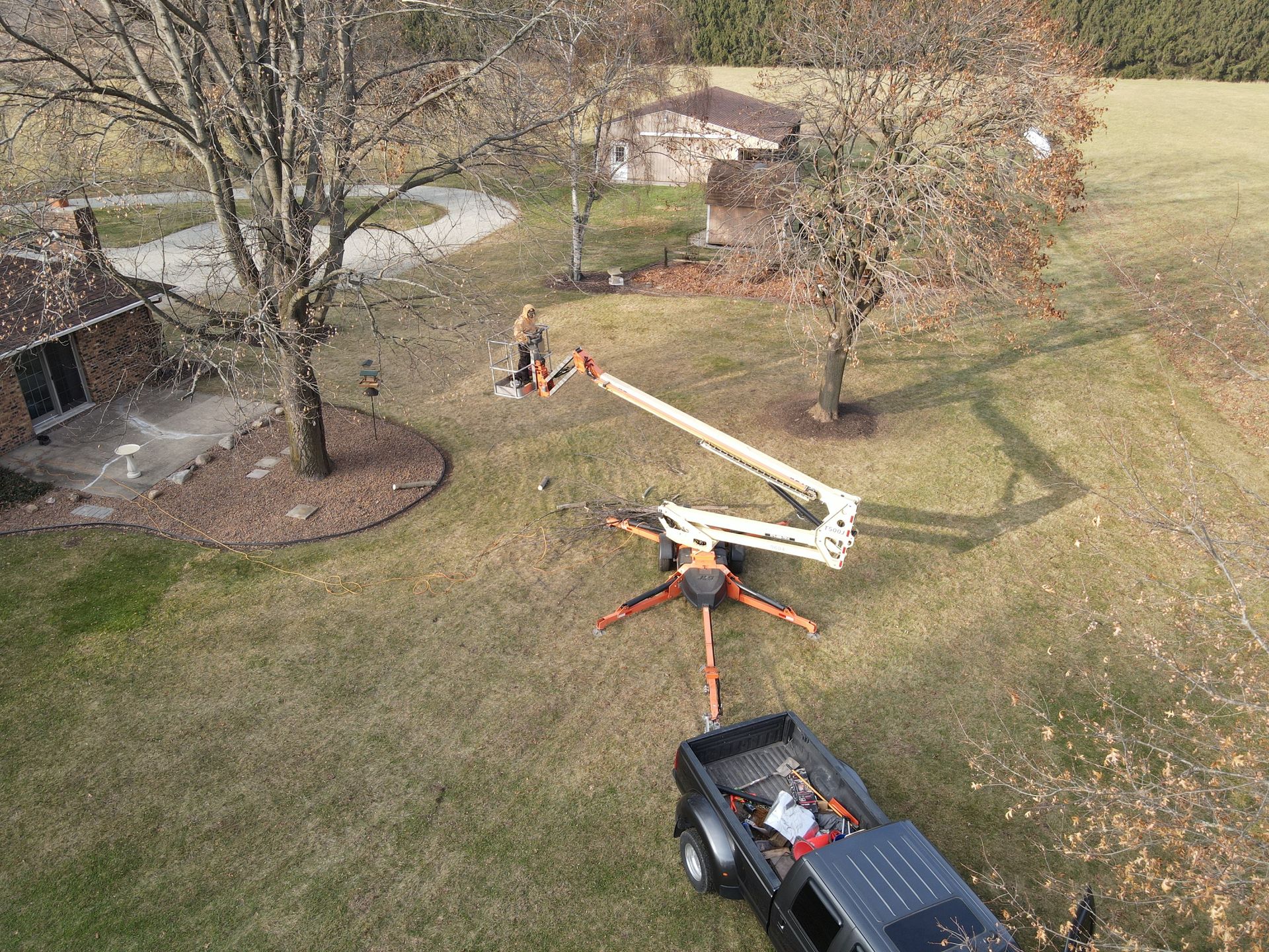 An aerial view of a truck and a crane in a yard.