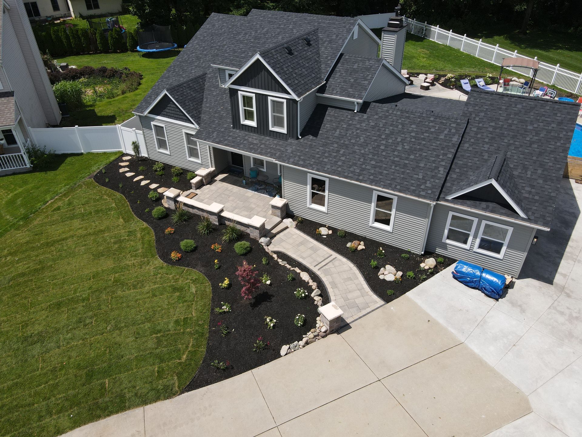An aerial view of a large house with a swimming pool in the backyard.