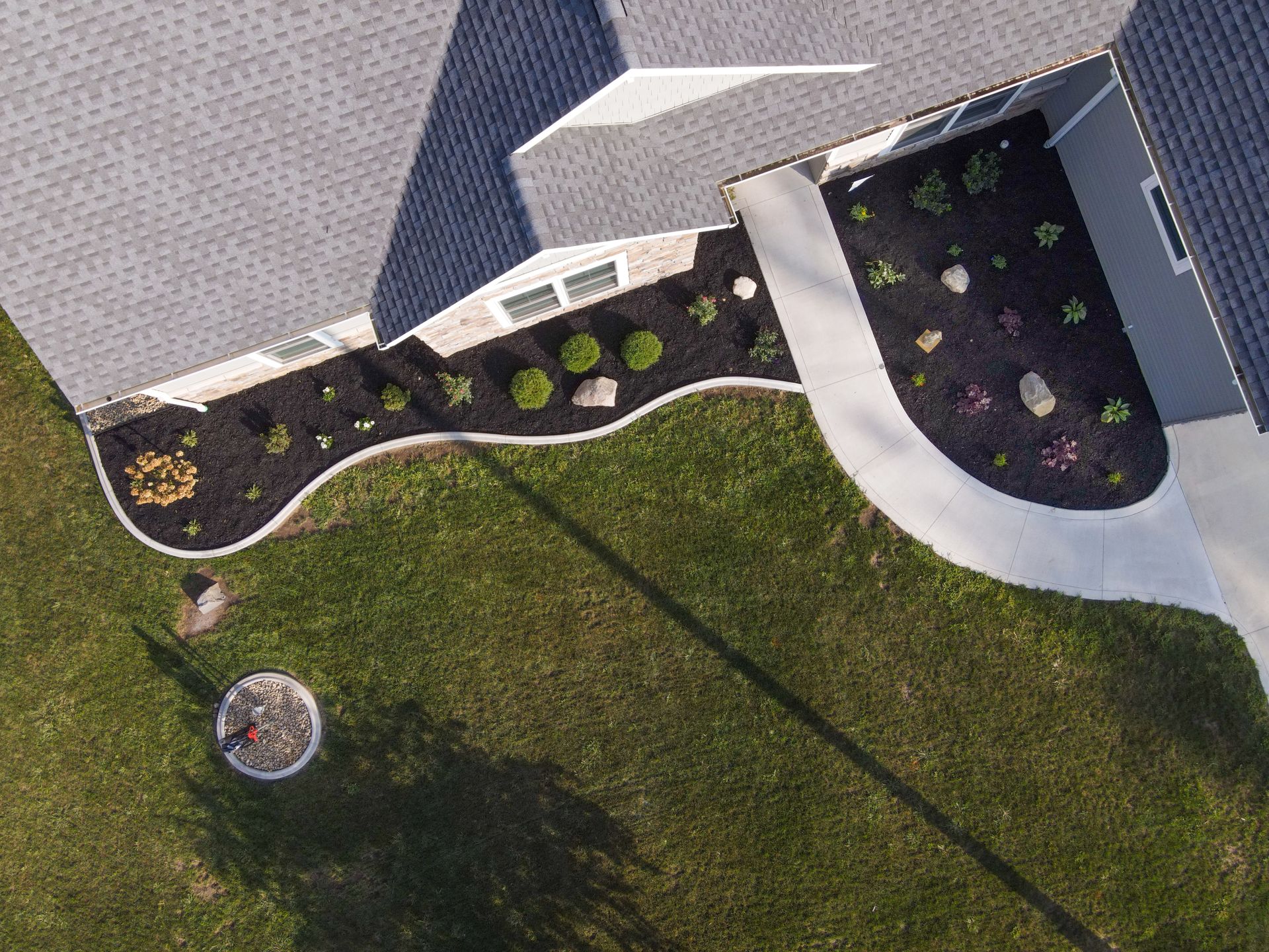 An aerial view of a house with a walkway and a lawn.