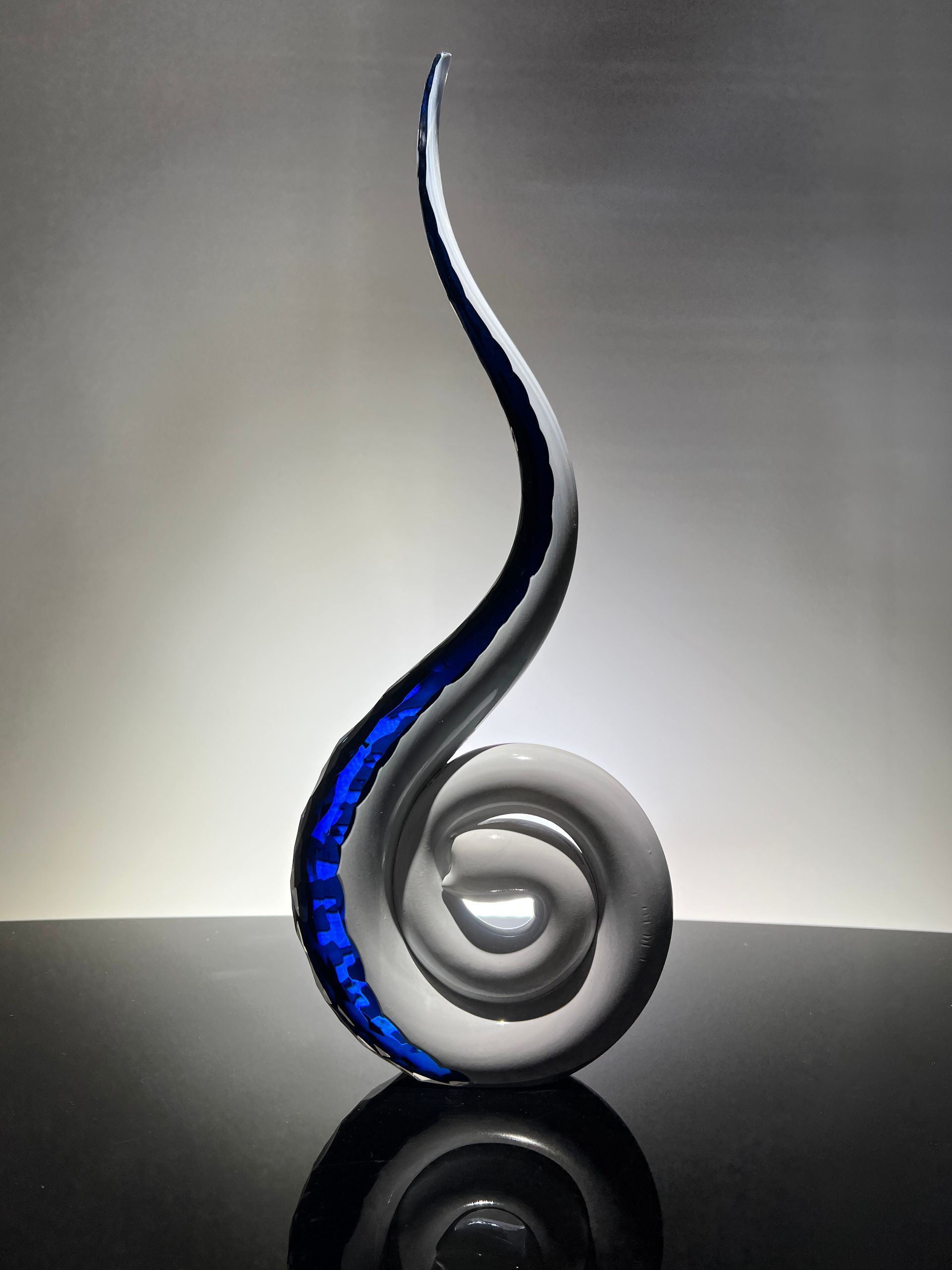 A blue and white swirl sculpture on a table