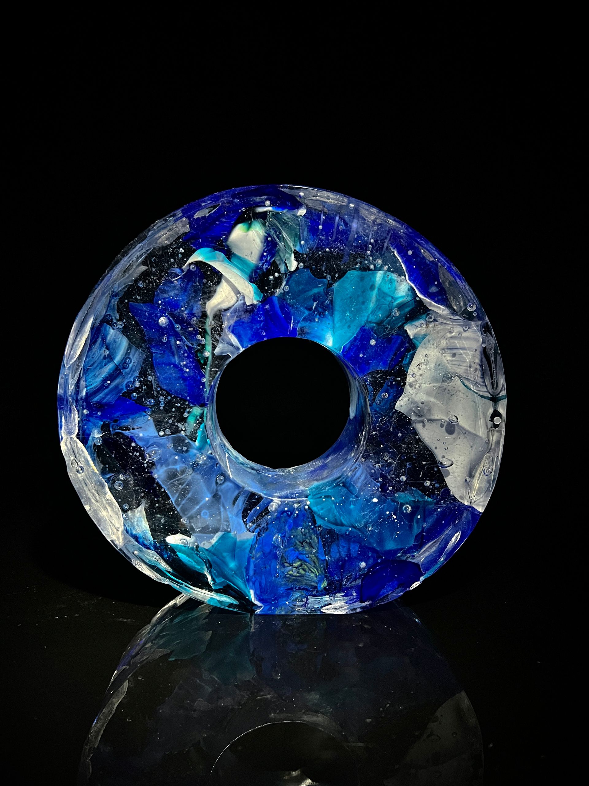 A blue and white glass circle with a hole in the middle..