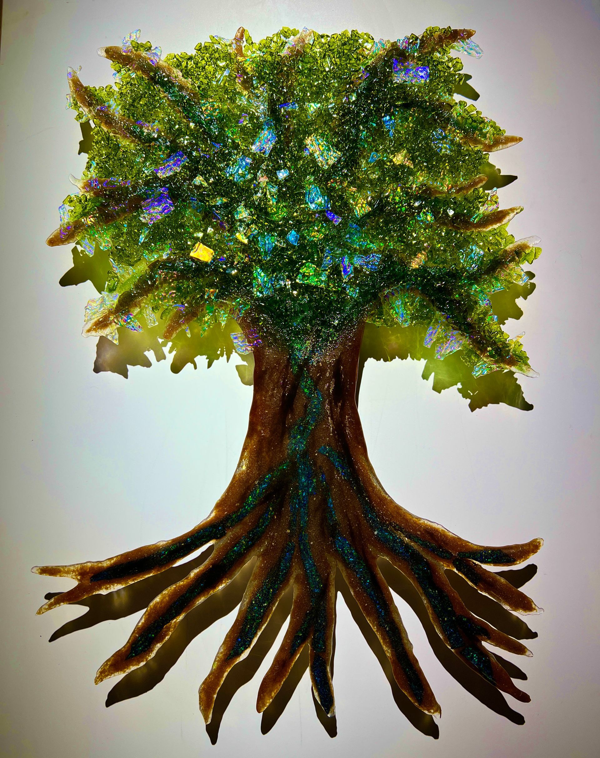 A glass tree with roots and green leaves