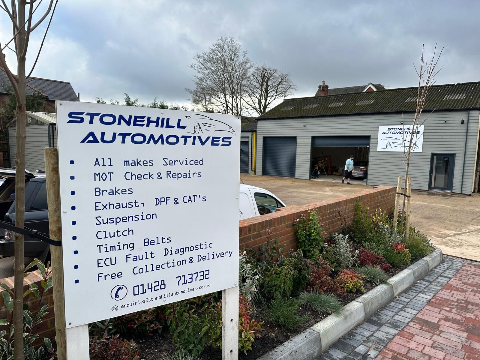 A sign for stonehill automotives is in front of a building