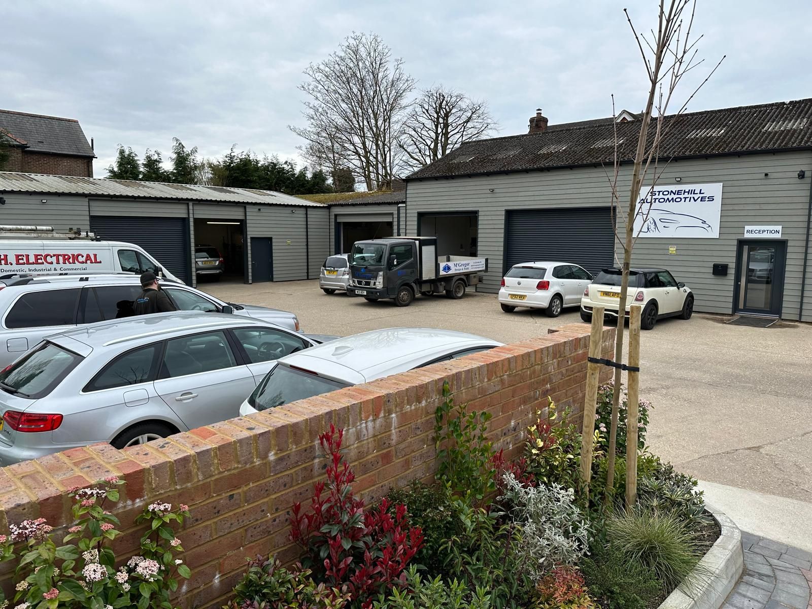 A lot of cars are parked in front of a building.