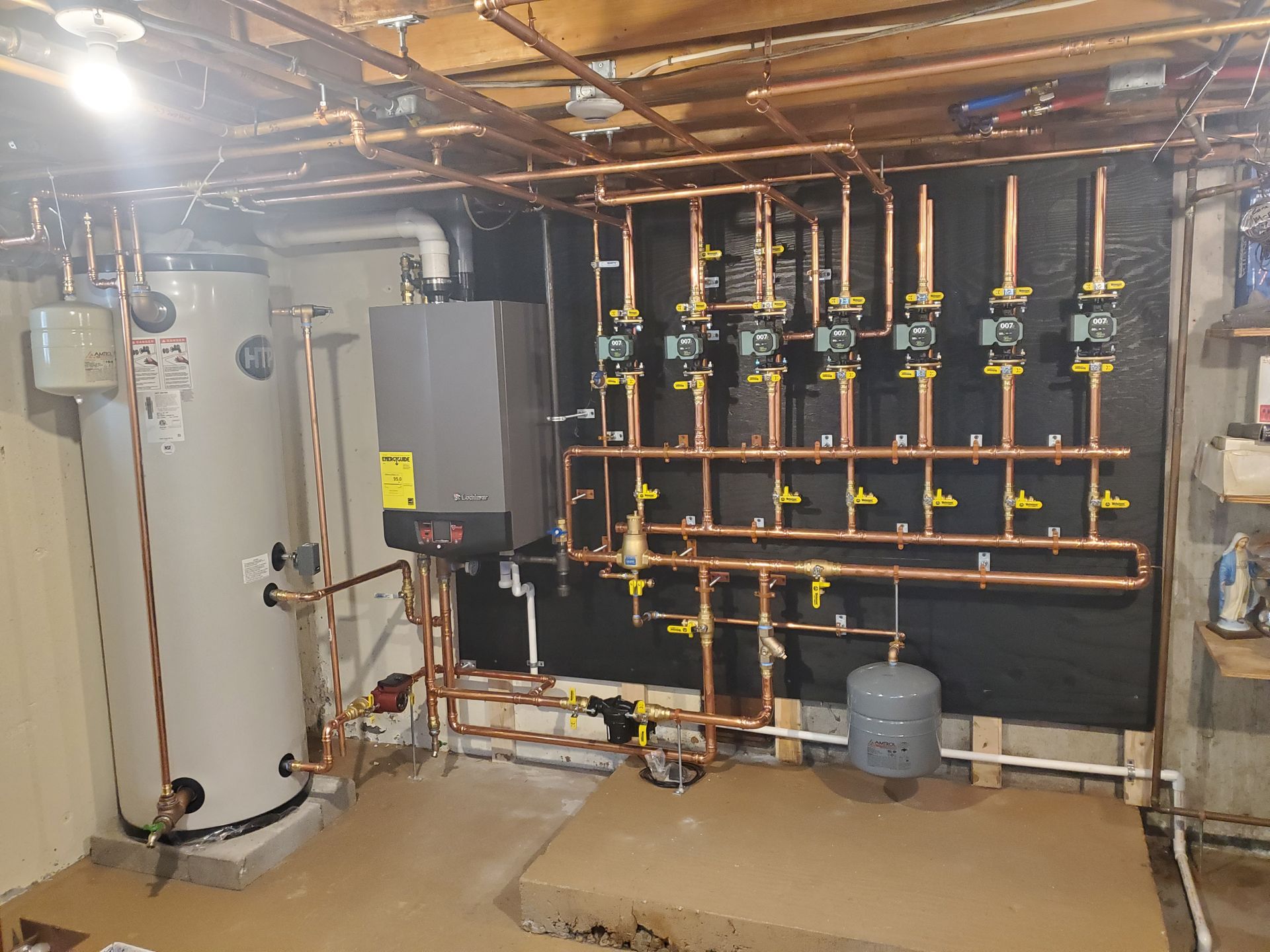 Copper pipes, a water heater, and heating system components in a basement.