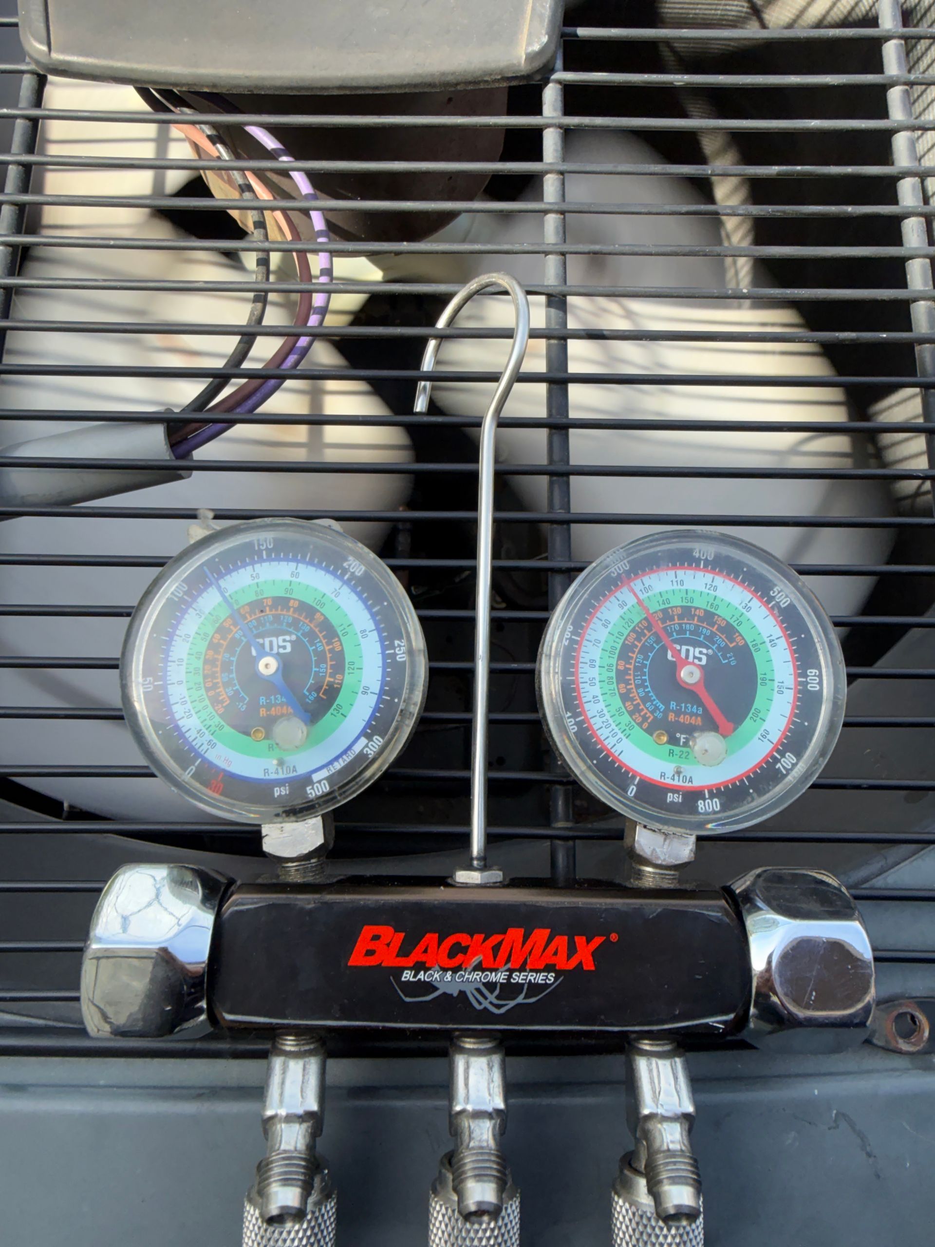 Blackmax dual gauges mounted on a grille, with colorful circular dials and tubing attached