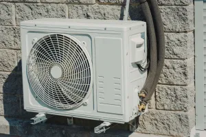 Rooftop HVAC units on a flat commercial roof beside a brick building and tall hotel tower