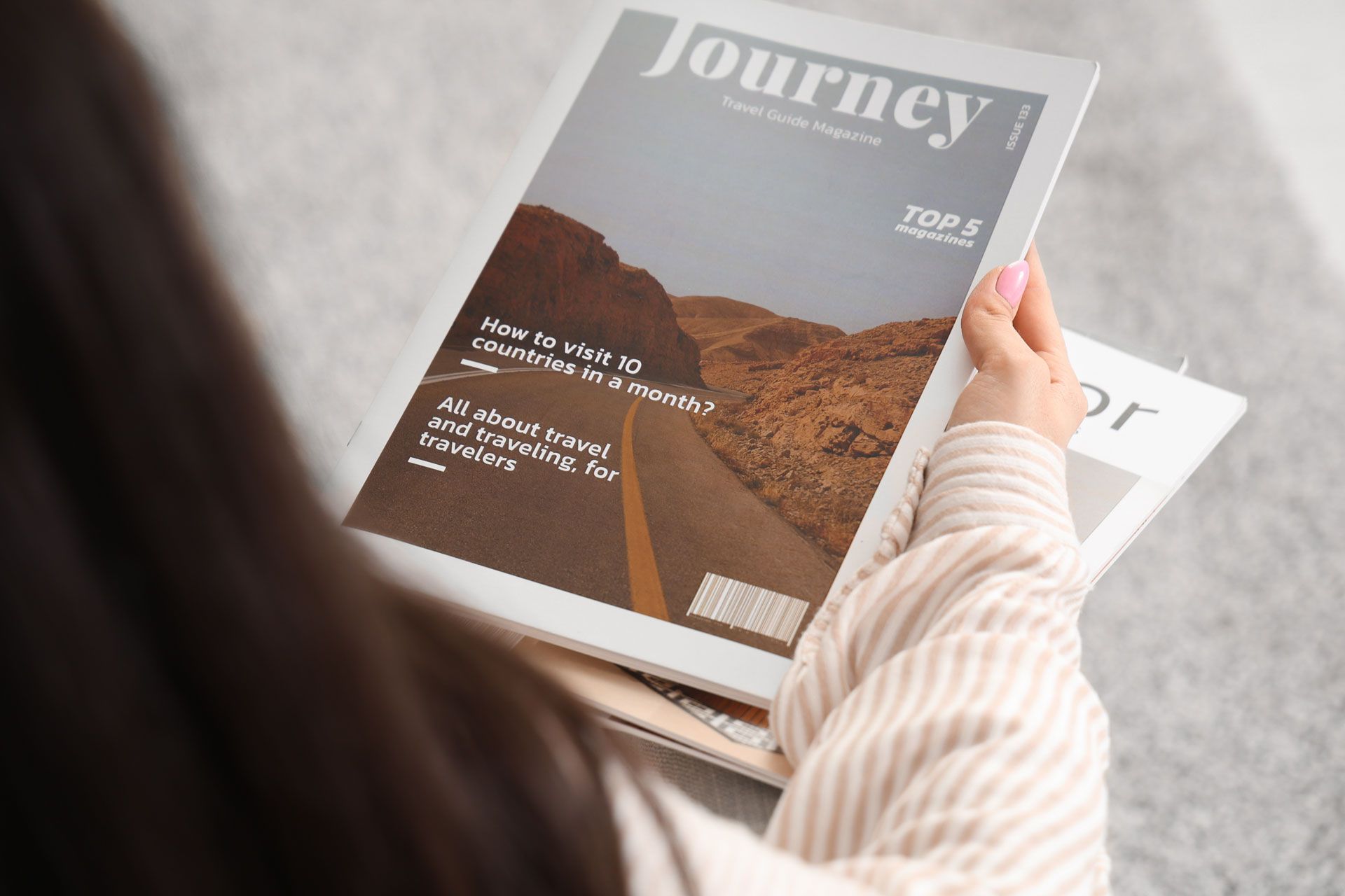 A person holds a travel magazine titled 