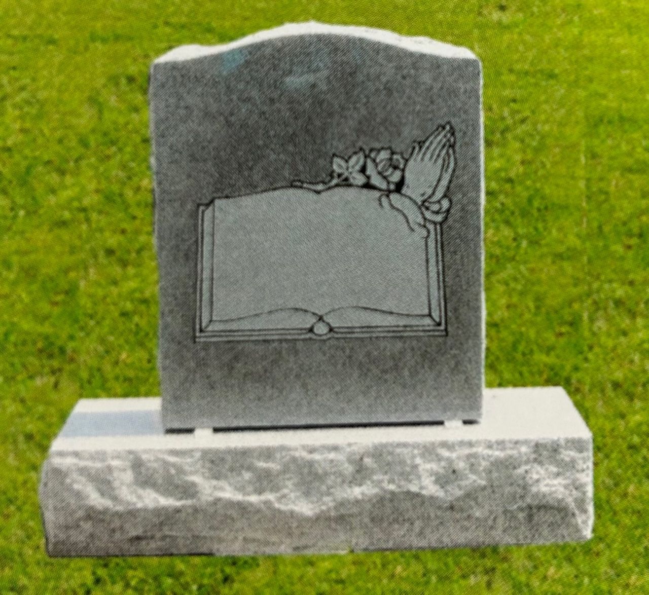 Gray headstone with open book design, praying hands, and flowers.