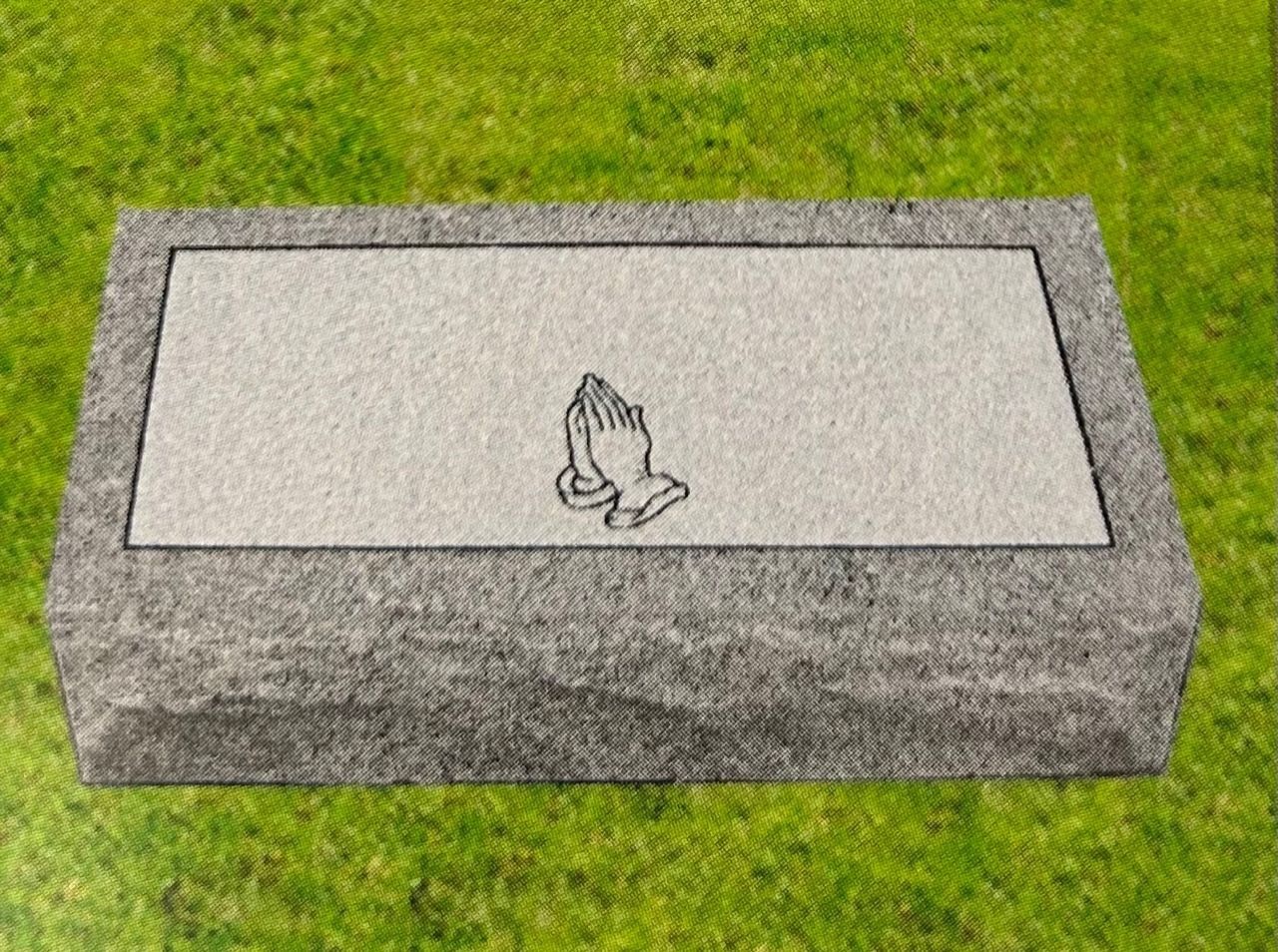 Headstone with praying hands symbol on grass.