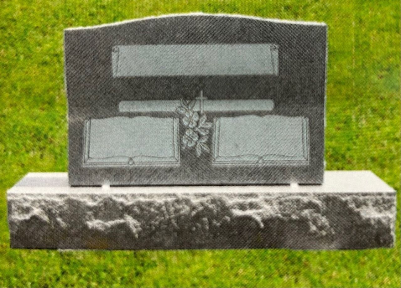 Gray granite headstone with blank inscription panels and floral carving on grass.