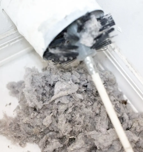 A vacuum cleaner is being used to clean a pile of dust.