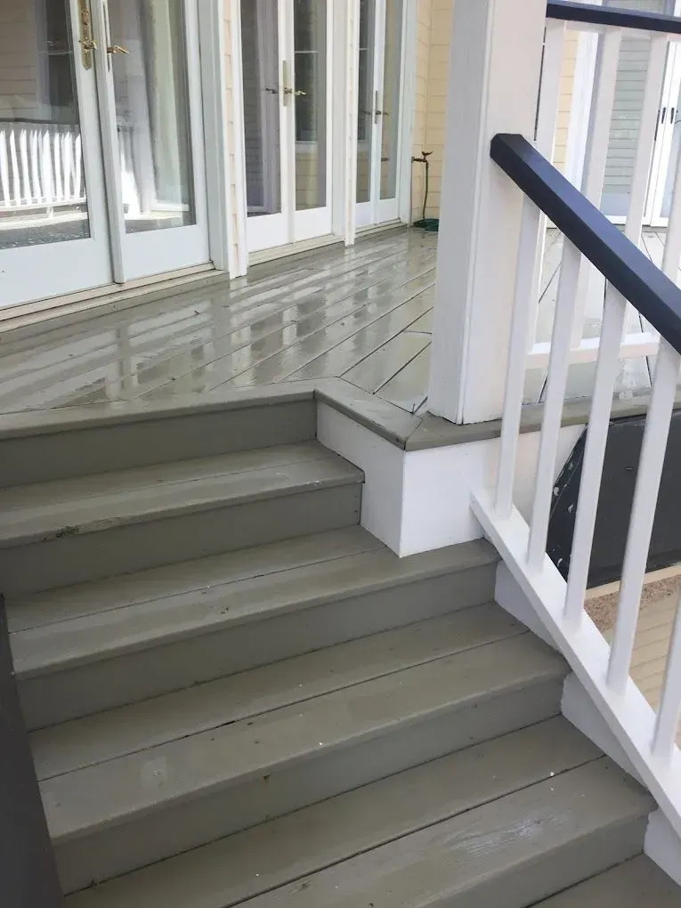 A set of stairs leading up to a deck with a railing.