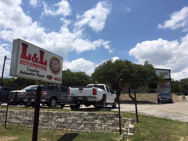 L&L Automotive sign with parked vehicles and a building on a sunny day. | QualTech Automotive