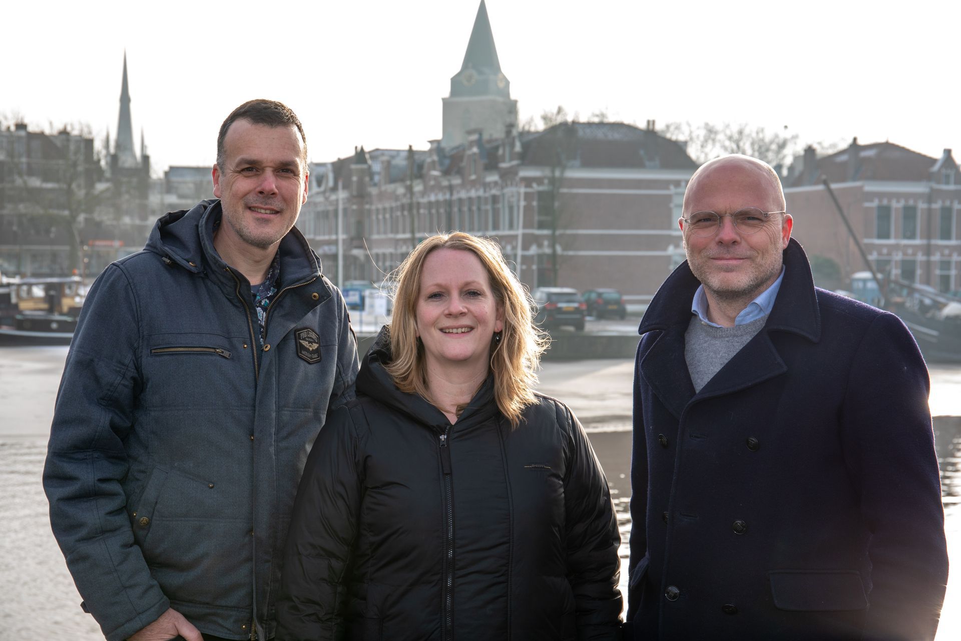 Stichting Leen teamfoto. Ernstjan Doornebal, Simone van der Velde en Vincent Nieuwehuizen. Stadsaanzicht haven Woerden.