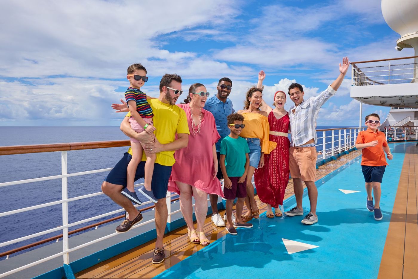 A group of people are posing for a picture on the deck of a cruise ship.