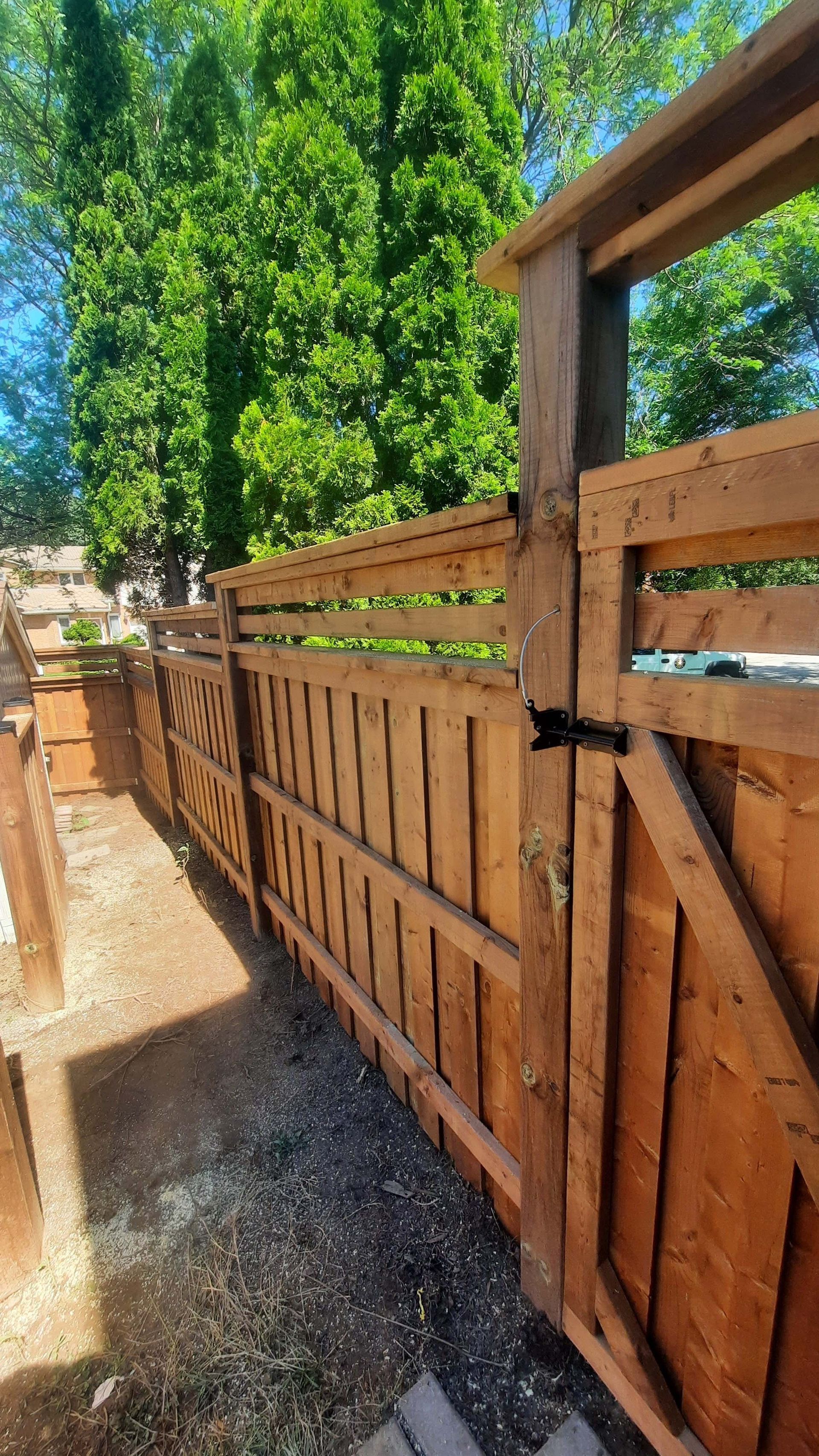 Wooden fence with a gate, brown, outdoor, daylight.