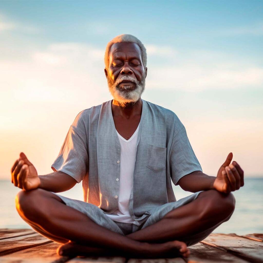 An older person sits in lotus position on a dock, eyes closed, hands open, ocean background, sunset.