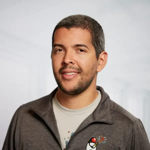 Um homem com barba está vestindo uma jaqueta com um pinguim nela