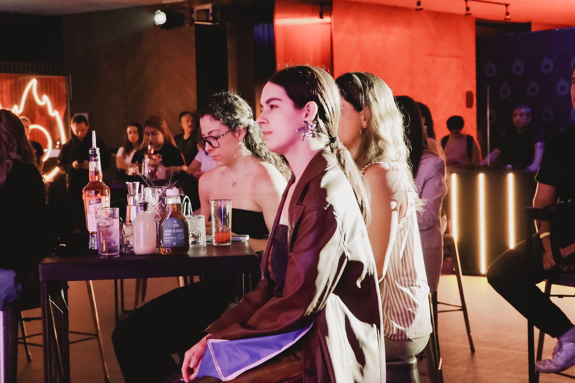 Um grupo de mulheres está sentado em mesas em um bar.