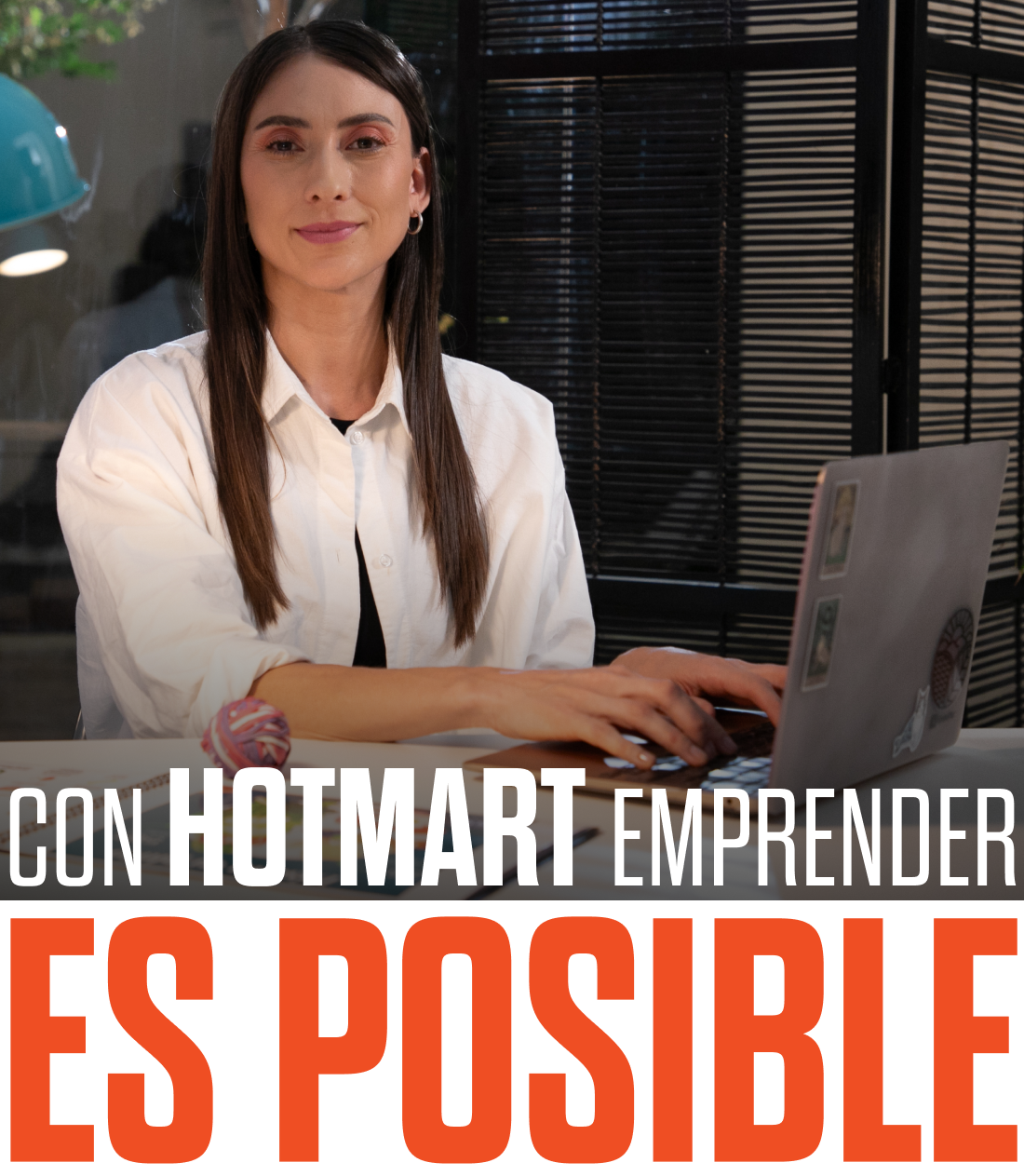 Uma mulher sentada em uma mesa com um laptop e as palavras con hotmart empreender es posible