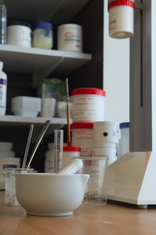 A white bowl with a mortar and pestle sits on a wooden table