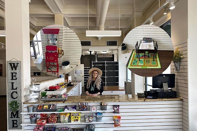 A woman is standing behind a counter in a store.