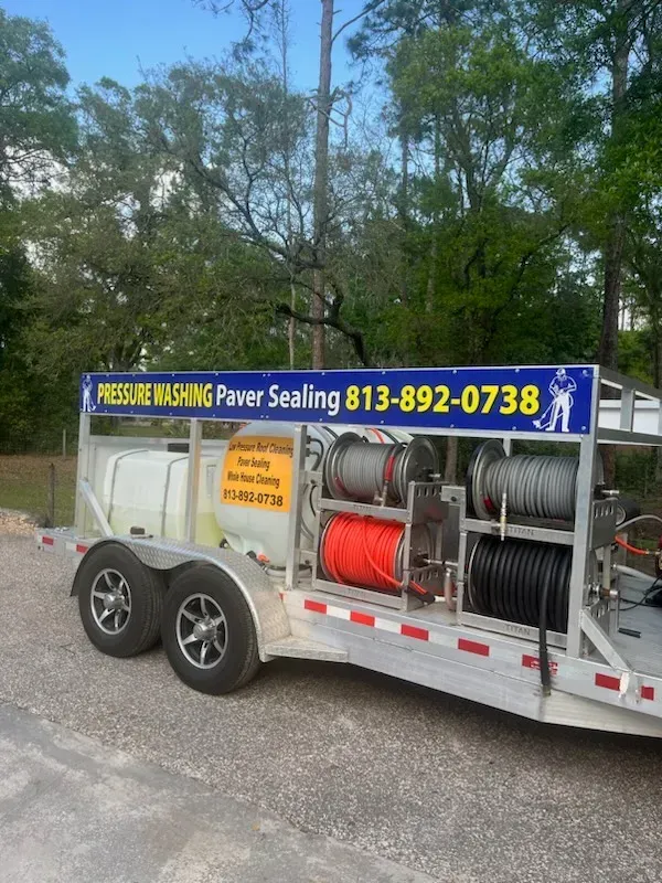 A trailer with a pressure washer on it is parked in a parking lot.