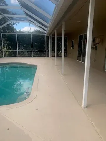 A large covered patio with a swimming pool in the background.