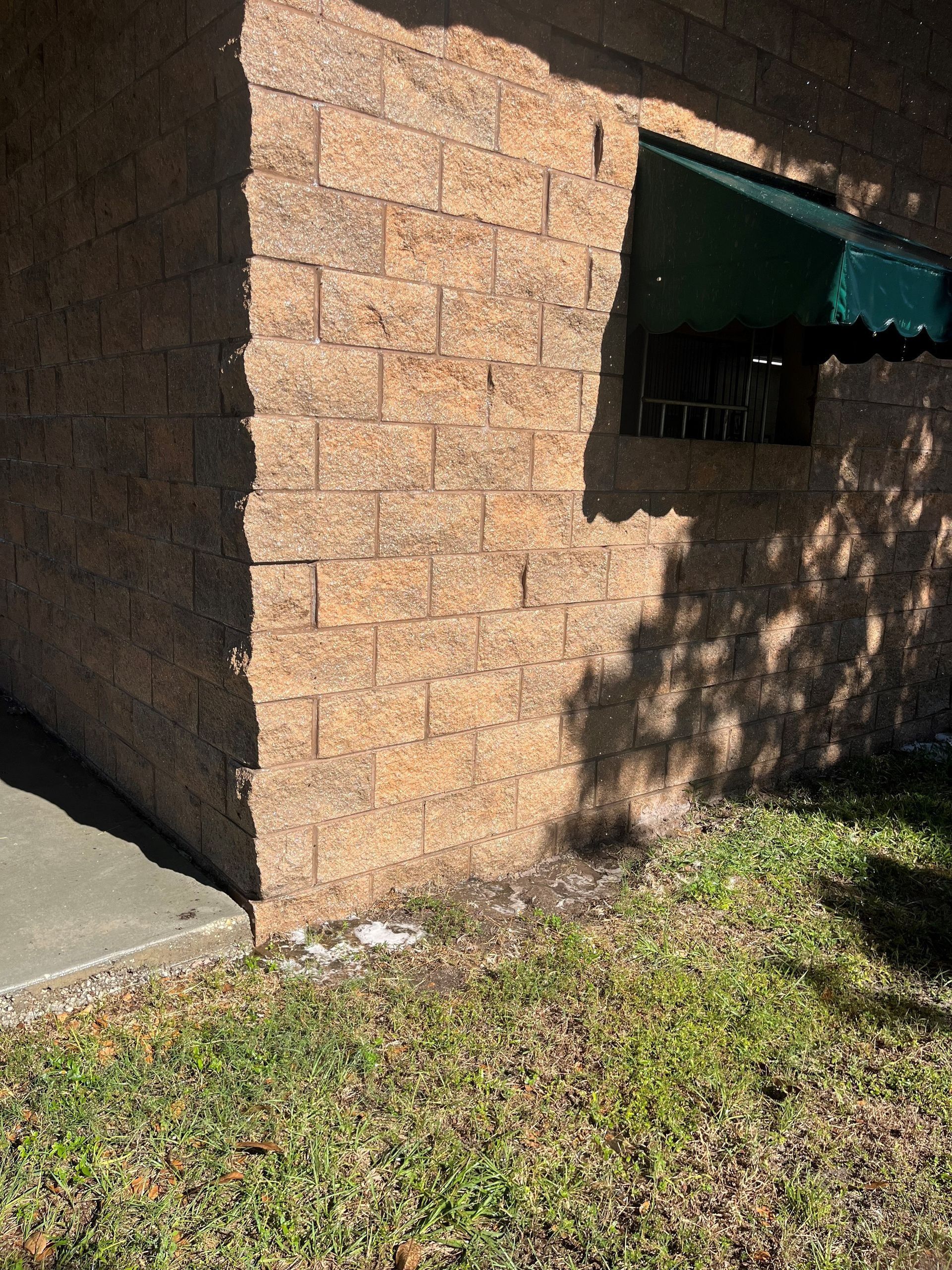 A brick wall with a green awning on the side of it.