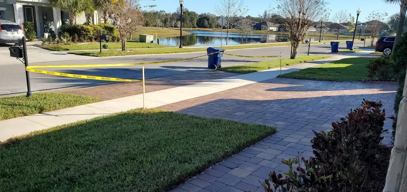 A residential neighborhood with a sidewalk and a brick walkway.