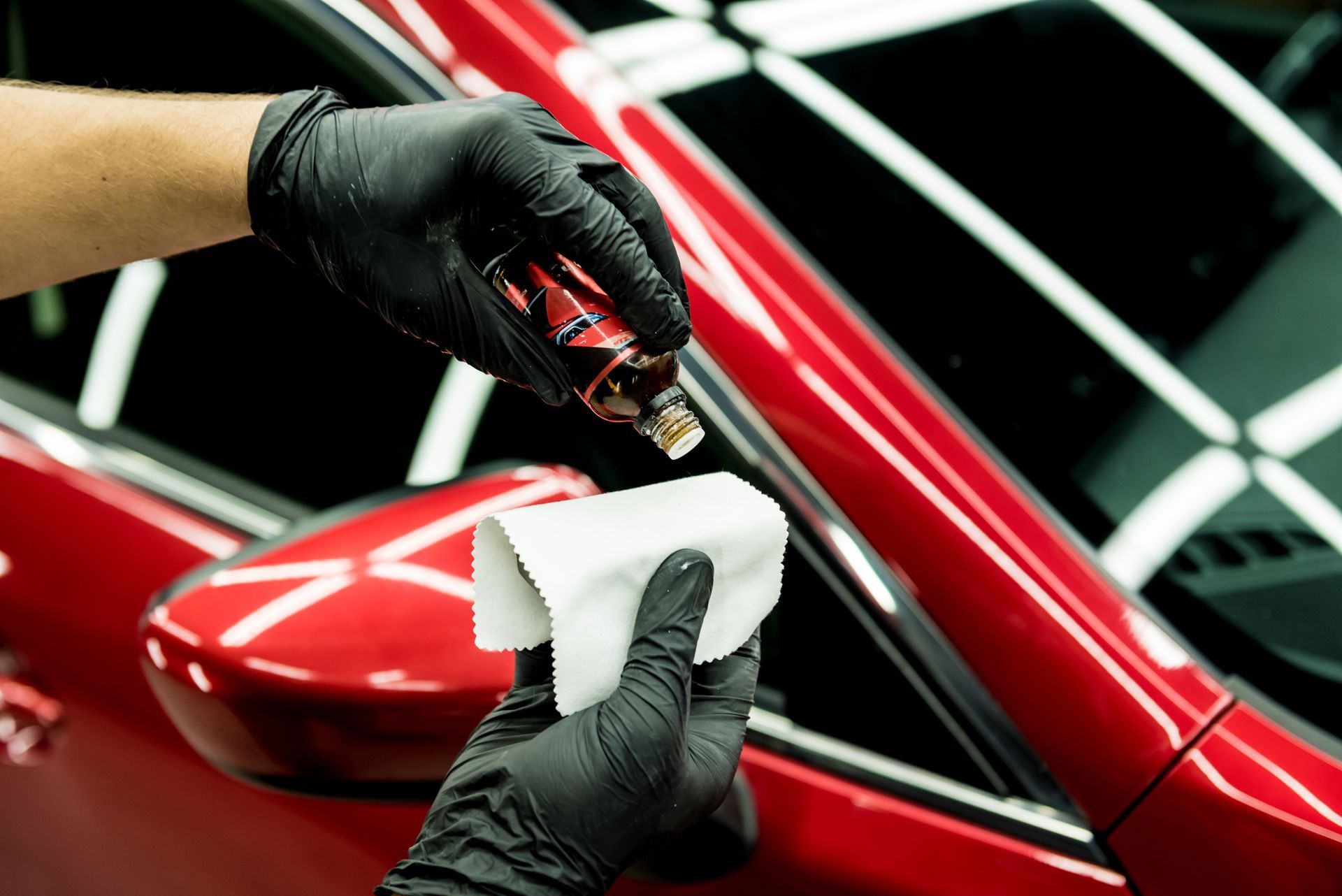 A Person Is Applying A Coating To A Red Car | Grapevine, TX | Driven by Detail