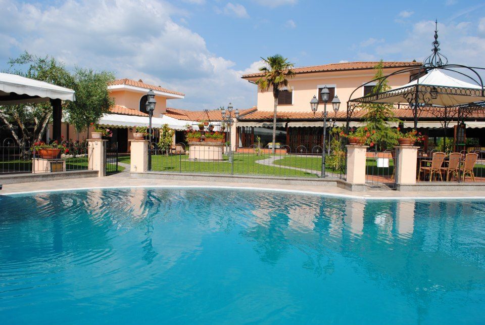 Piscina con edifici sullo sfondo e cielo azzurro.