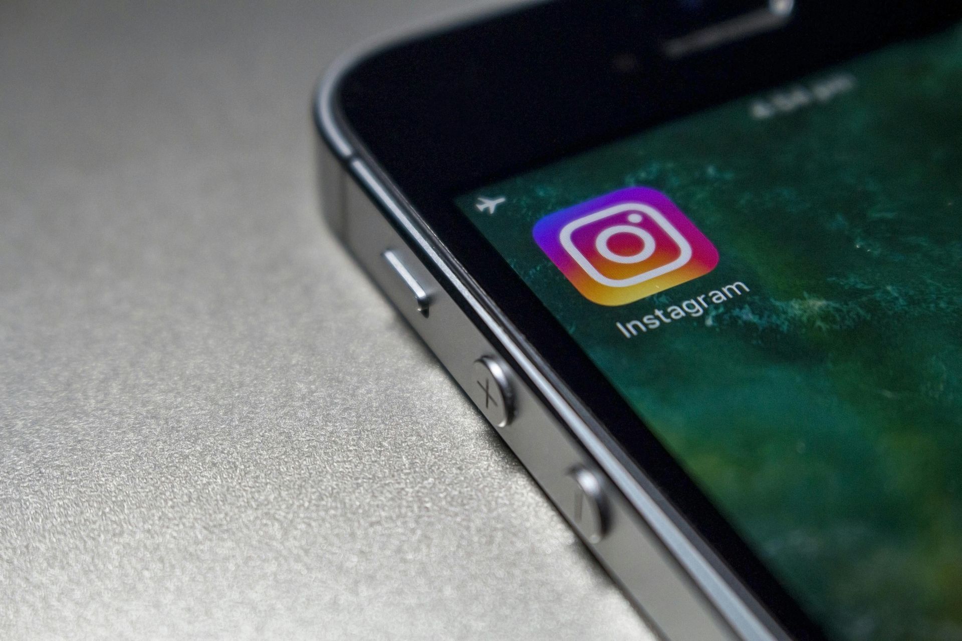Black smartphone with the Instagram app icon on the screen.