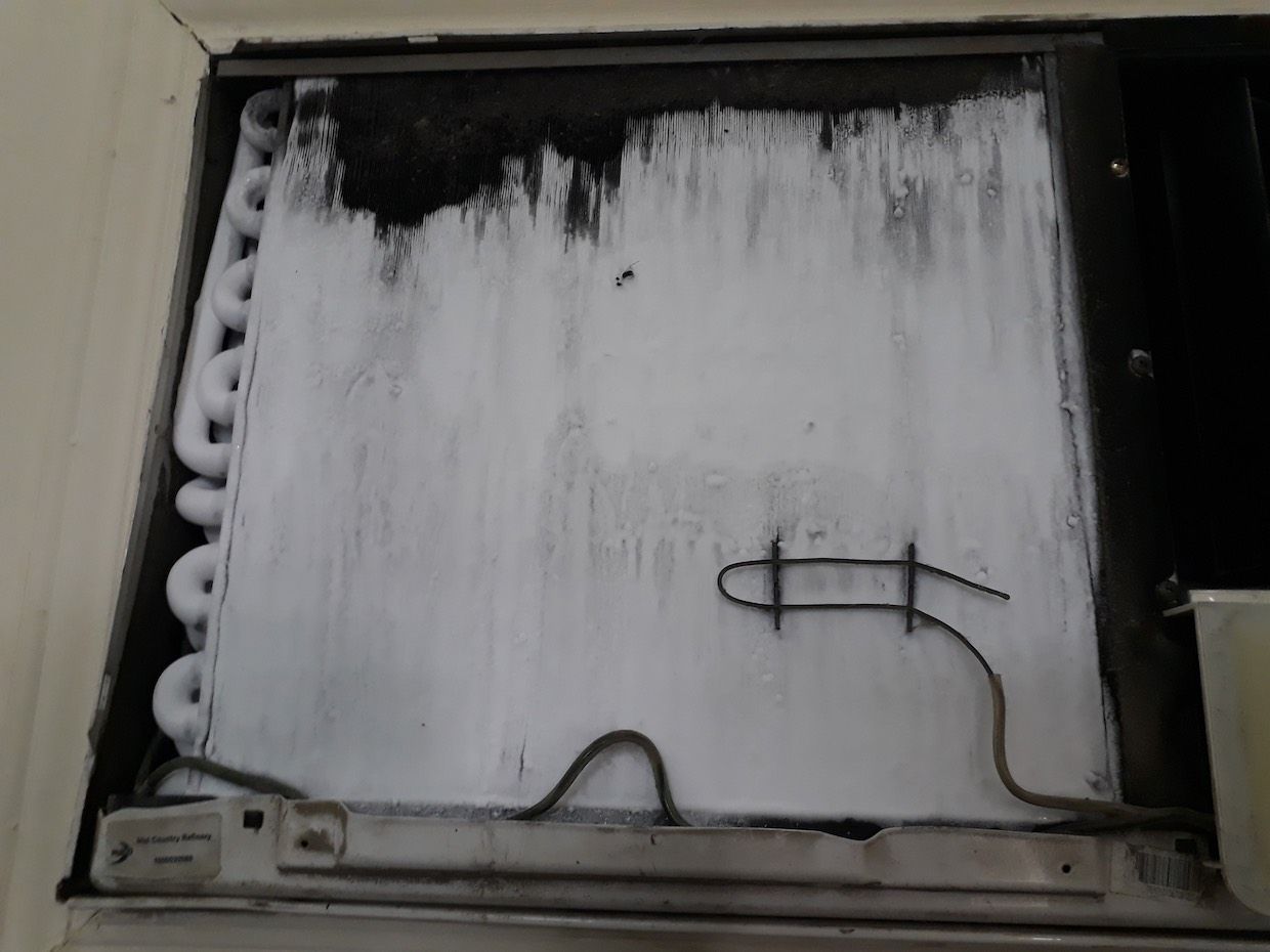 Looking through the vents of an AC unit a fan blade stays motionless