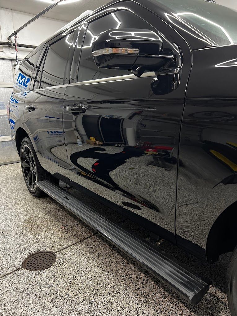 A black suv is parked in a garage.