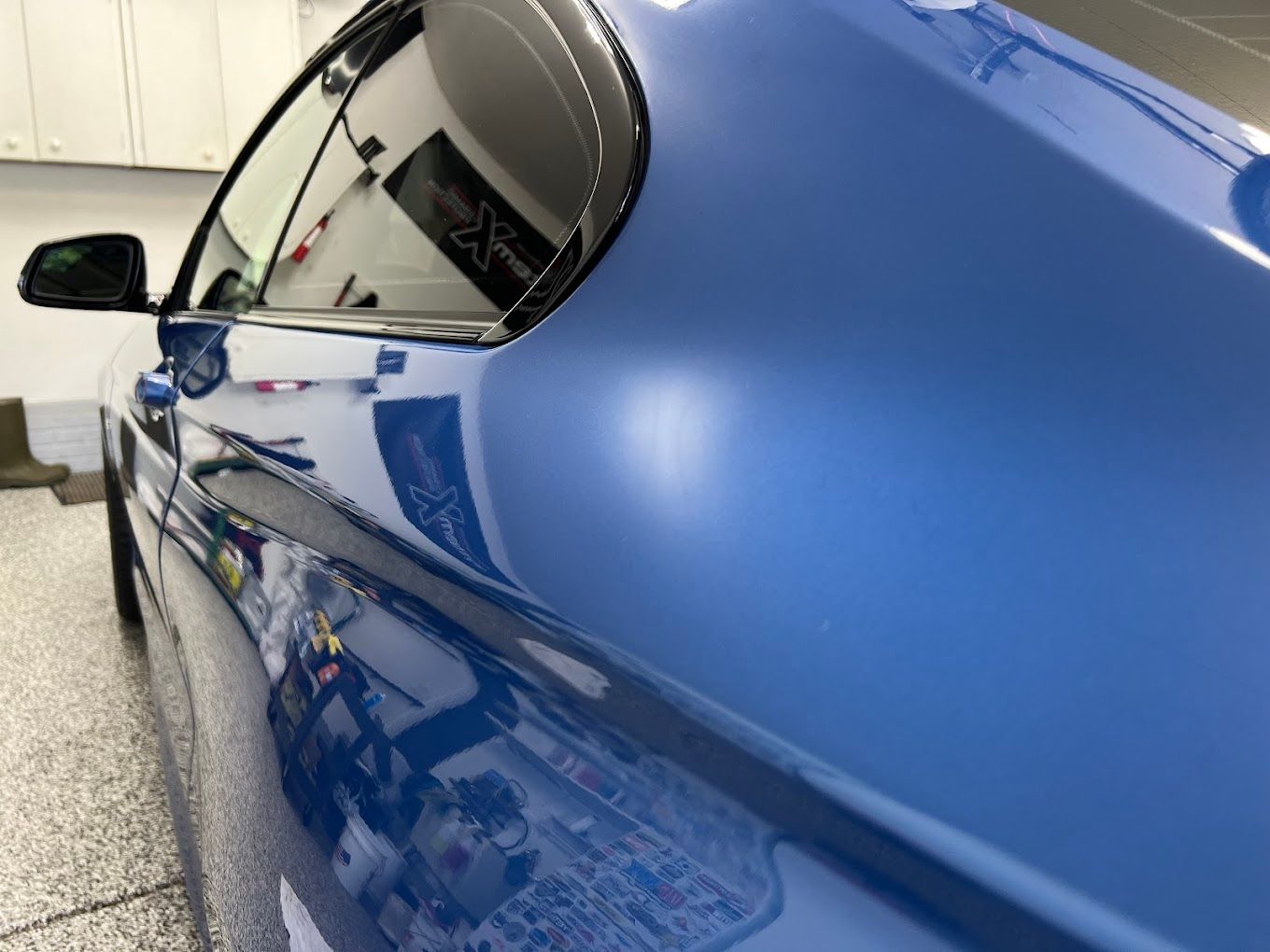 A close up of a blue car in a garage