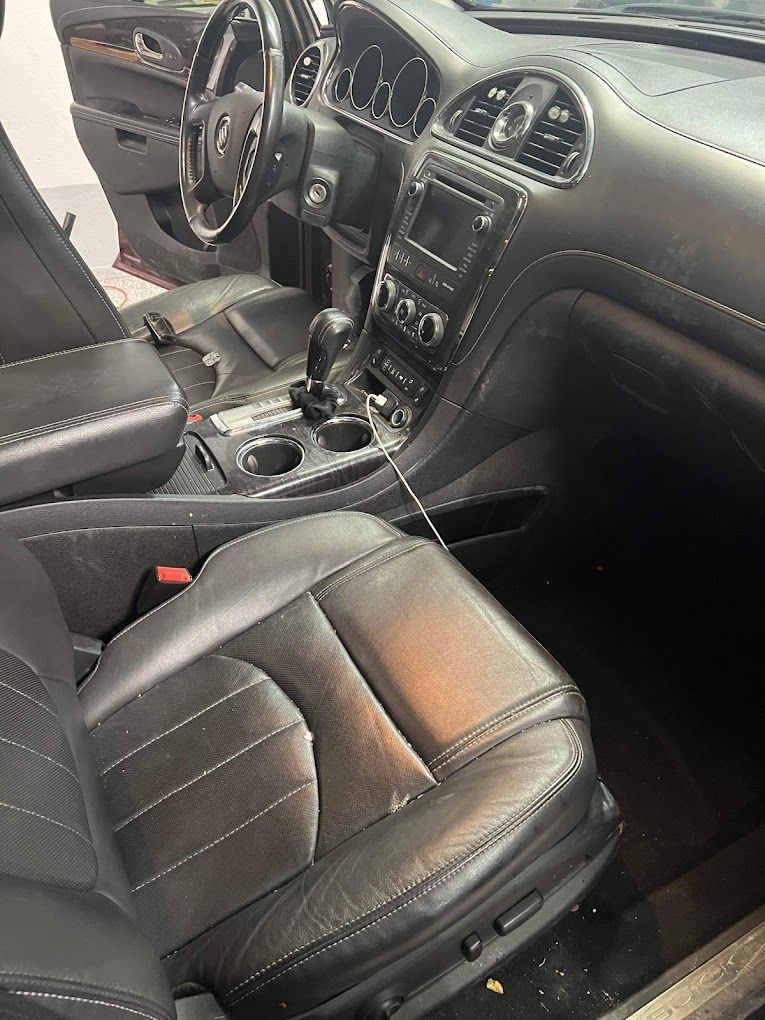The interior of a car with black leather seats and a steering wheel.