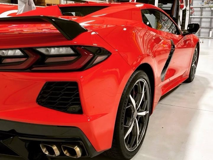 A red sports car is parked in a garage