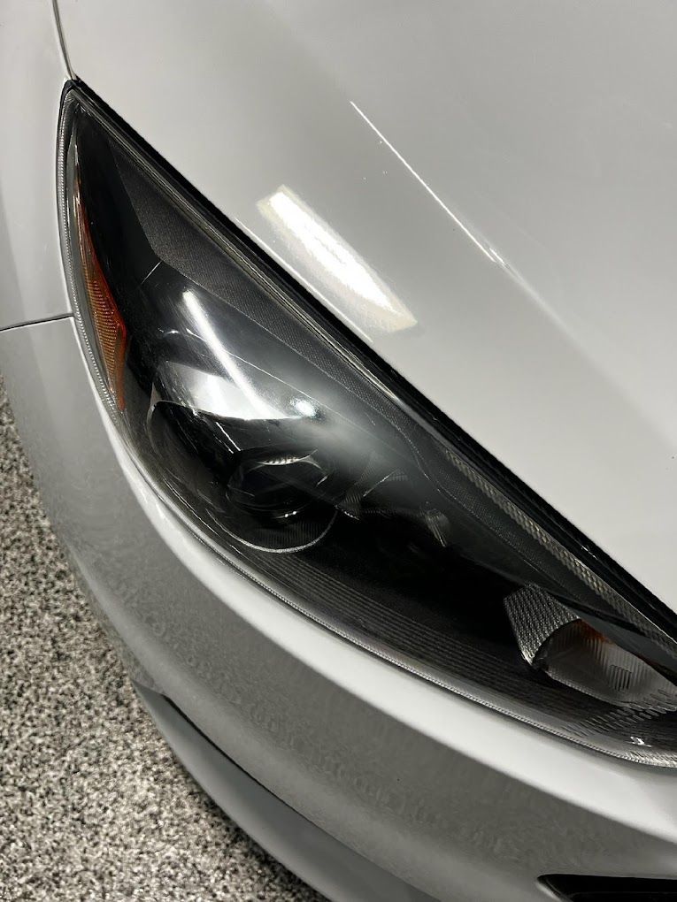 A close up of a car 's headlight in a garage.