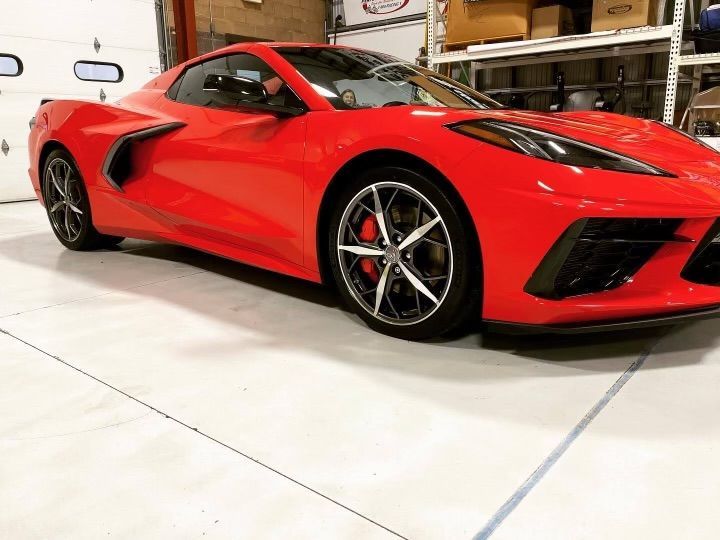 A red sports car is parked in a garage.