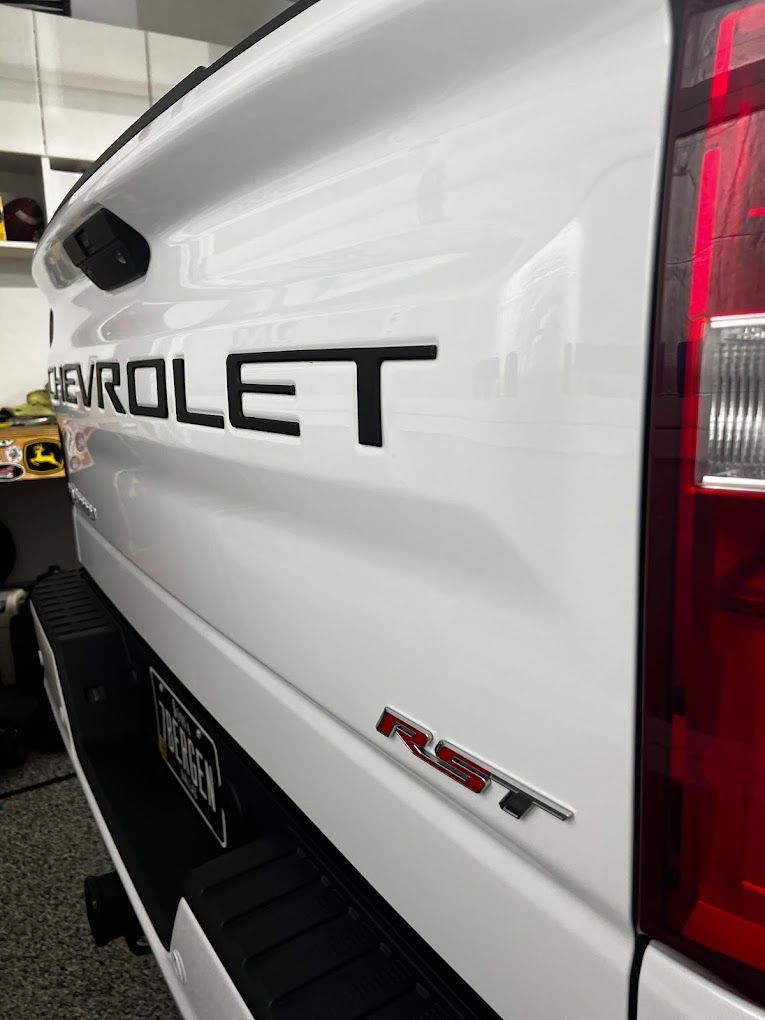 A white chevrolet truck is parked in a garage