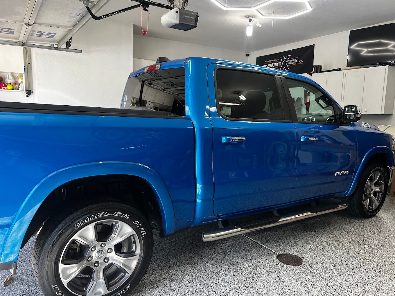 A blue pickup truck is parked in a garage.